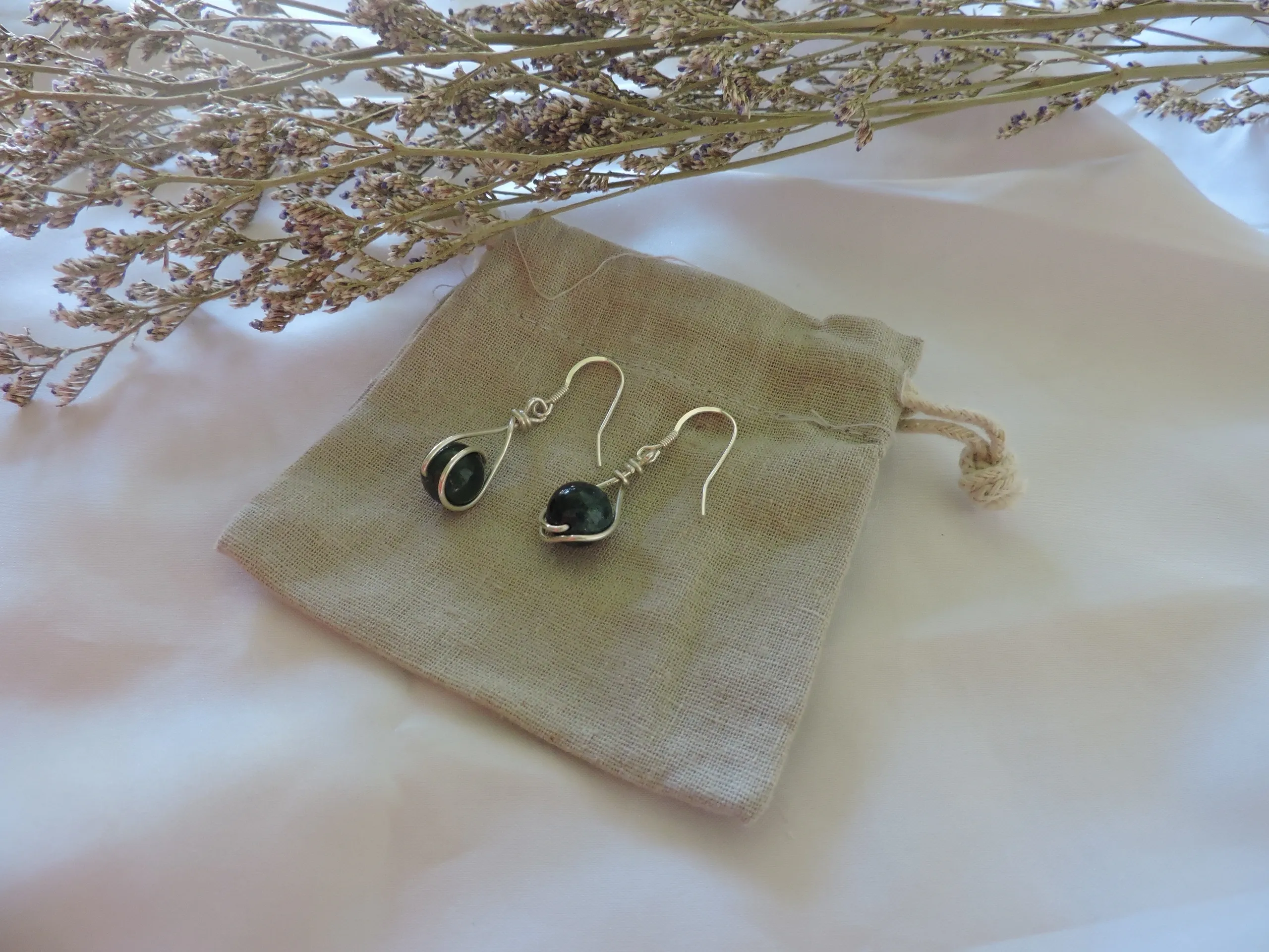 Love to Muse products styled with a fabric pouch, soft textile and dried stems.